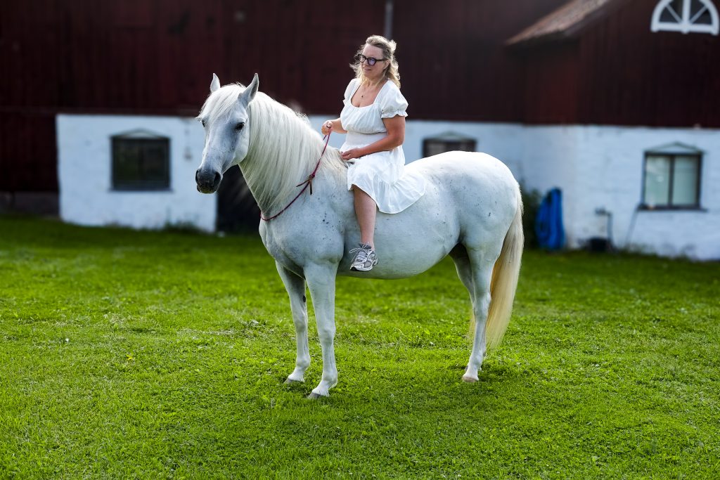 Annika Lif, iförd klänning, sitter på Musica iförd enbart halsring.